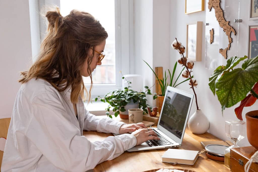 woman freelancer working on laptop from cozy home 5CUSKJJ 1